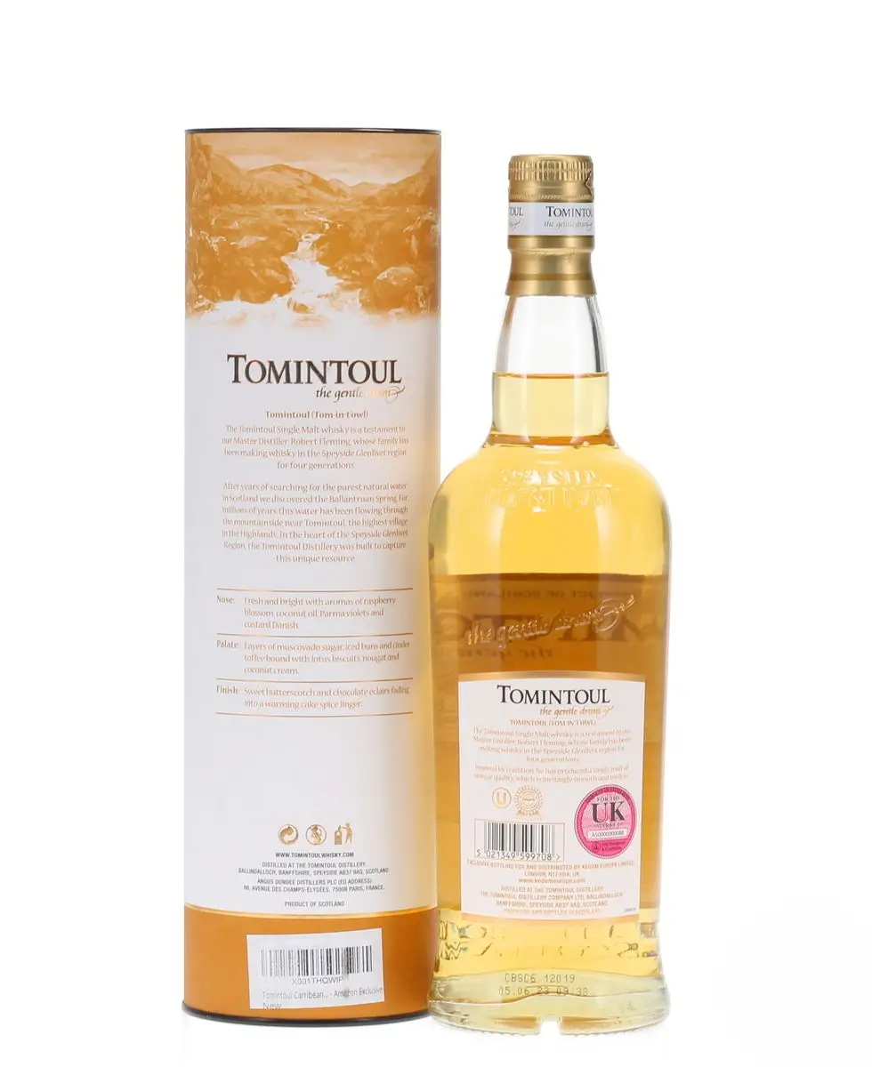 tomintoul caribbean rum cask finish clear bottle standing beside yellow and white tin rear image
